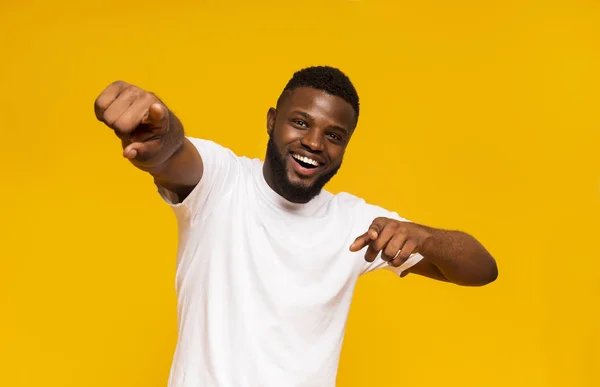 Vidám afrikai férfi boldogan jelzi a kamera, sárga stúdió háttér — Stock Fotó