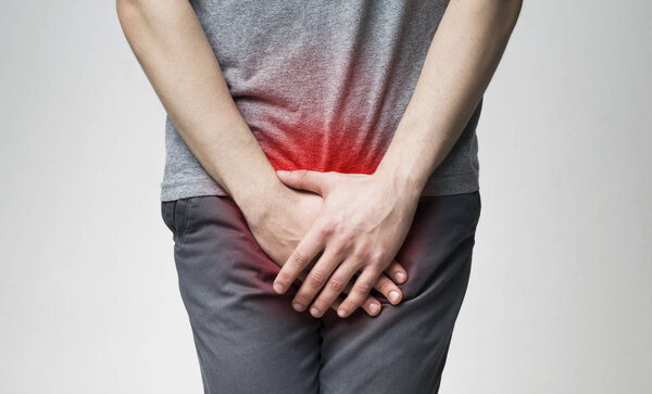 Man holding his urethra in pain. Men problems