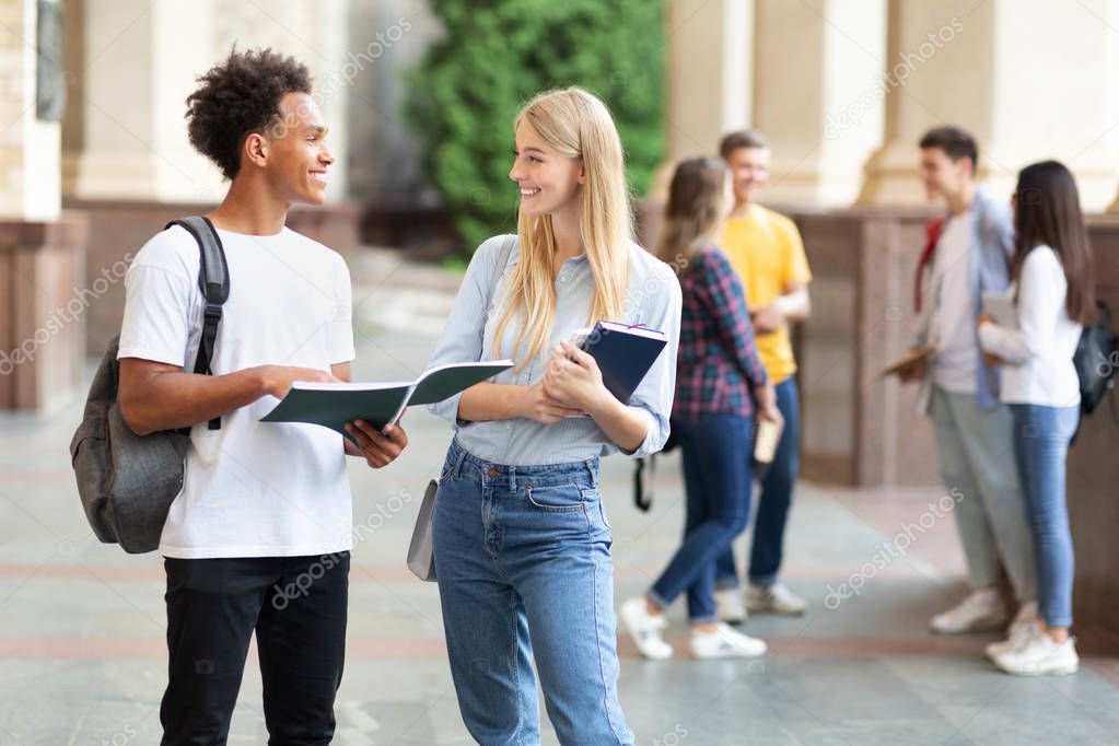Teen friends preparing for lecture in university campus