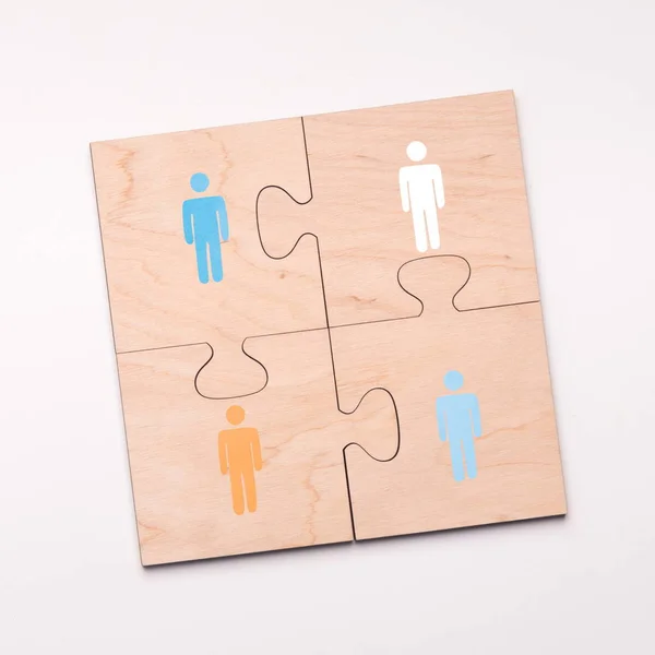 Puzzle di quattro pezzi con persone che si connettono per aiutare — Foto Stock