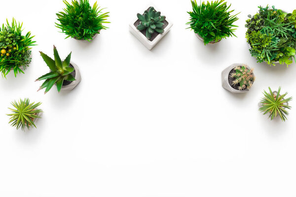 Border of artificial plants in pots on white background