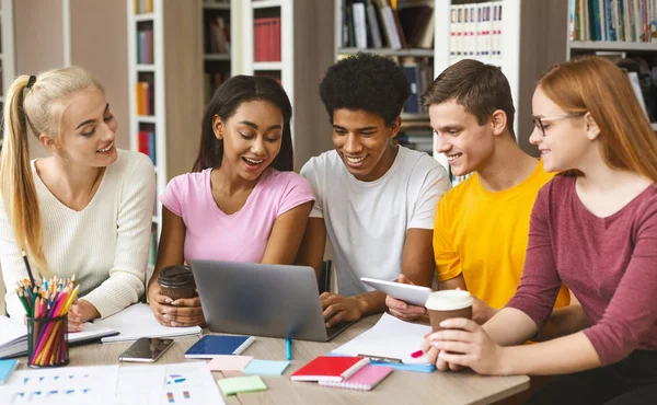 Grupo de jovens que trabalham com laptop na biblioteca — Fotografia de Stock