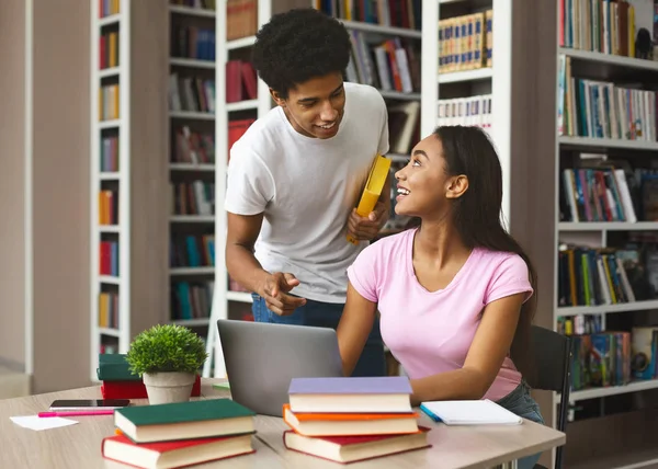 Noir guy offre soutien pour afro fille dans bibliothèque — Photo