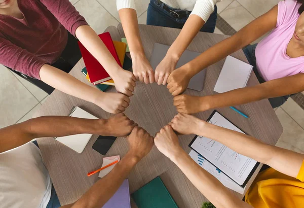 Multietniska studenter gå med händerna tillsammans i samarbete — Stockfoto