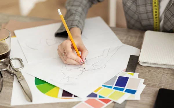 Fashion designer drawing sketches for clothes in atelier — Stock Photo, Image