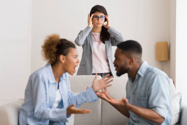 Confuso conselheiro matrimonial testemunhando casal negro discutindo durante a terapia — Fotografia de Stock