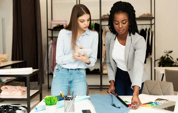 Jóvenes diseñadores de moda trabajando en la nueva línea de ropa en Atelier — Foto de Stock