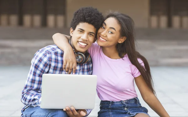 Happy studenter poserar på kameran när du använder laptop tillsammans utomhus — Stockfoto