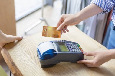 Butikte kredi kartı nı kaydıran kadın satış asistanı
