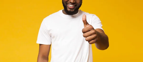 Ευχαριστημένος άνθρωπος που δείχνει τον αντίχειρά του, χαμογελαστός γενικά σε κίτρινο φόντο — Φωτογραφία Αρχείου