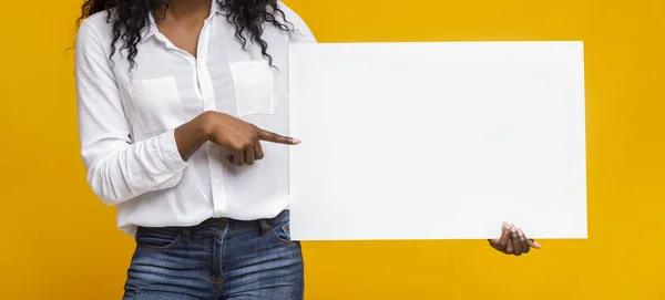 Afro menina está apontando para placa de publicidade amarela — Fotografia de Stock