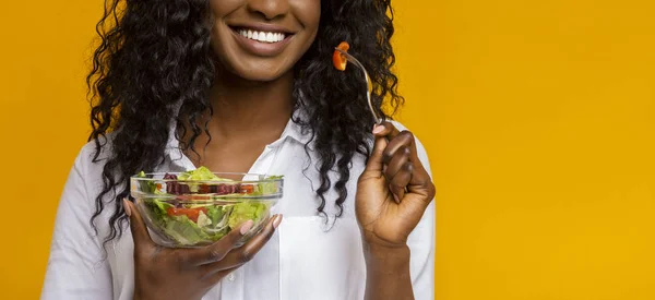 Sonriente chica afroamericana comiendo ensalada de verduras — Foto de Stock