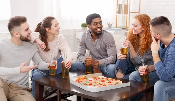 Vrienden praten, eten van pizza en bier drinken — Stockfoto