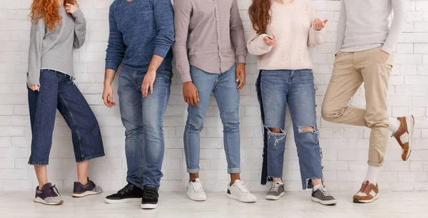 Piernas de amigos con estilo, de pie sobre la pared blanca — Foto de Stock