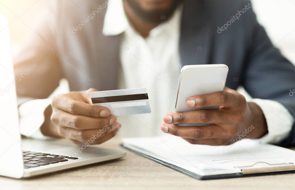 African man checking details of his online purchase in smartphone