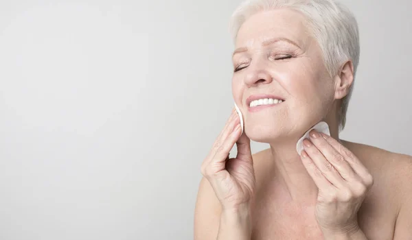 Senior vrouw genieten van haar schoonheid en gezichtsverzorging routine — Stockfoto