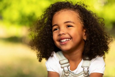 Sevimli afro kız geniş açık havada gülümseyen, ebeveynleri ile piknik sahip