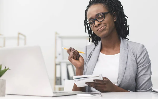 Niezadowolony Afro businesswoman biorąc notatki organizowanie harmonogramu w pracy — Zdjęcie stockowe