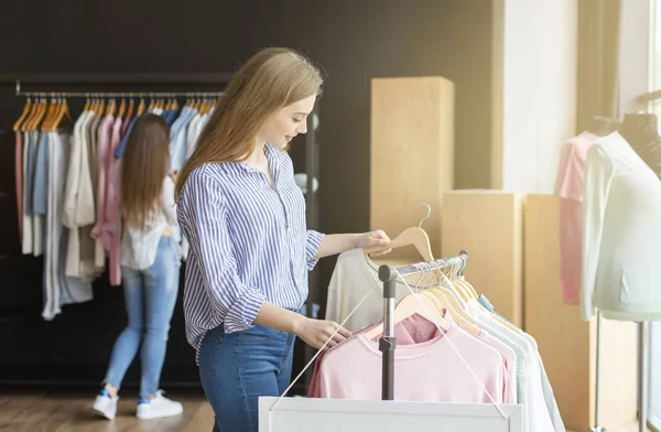 Mooi meisje kiezen nieuwe trui in showroom — Stockfoto