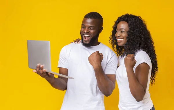 Feliz casal negro celebrando o sucesso com laptop — Fotografia de Stock