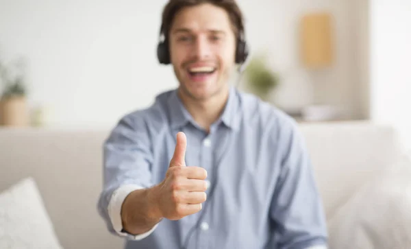 Opgewonden man Gesturing thumbs-up luisteren naar muziek via draadloze hoofdtelefoon — Stockfoto