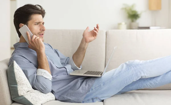 Homme se plaignant de mauvais service par téléphone allongé sur le canapé — Photo