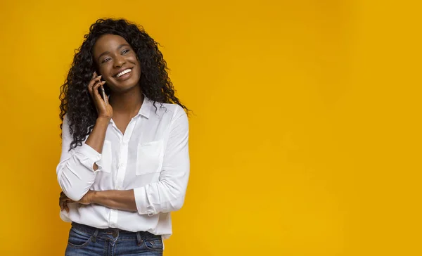 Африканская американка разговаривает по мобильному телефону и улыбается — стоковое фото