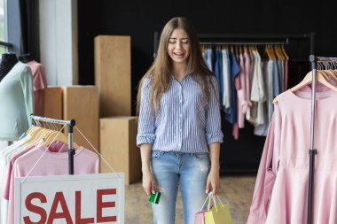 Üzgün kız umutsuzca alımları ve kredi kartı tutan