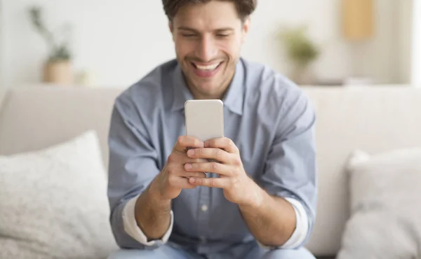 Emocionado joven jugando en Smartphone en casa — Foto de Stock