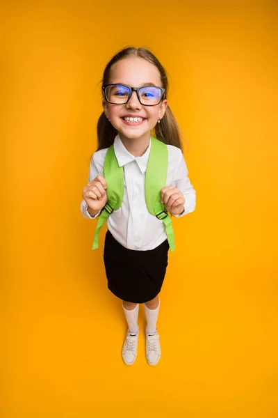 Felice scuola elementare ragazza in occhiali sorridente a fotocamera ad alto angolo — Foto Stock