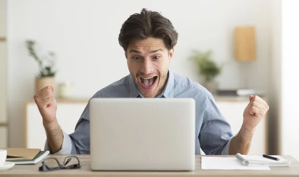 Excited Man Celebrating His Victory At Laptop In Office