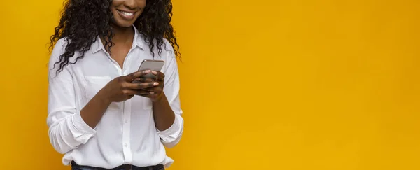 Chica afroamericana usando teléfono celular sobre fondo amarillo — Foto de Stock