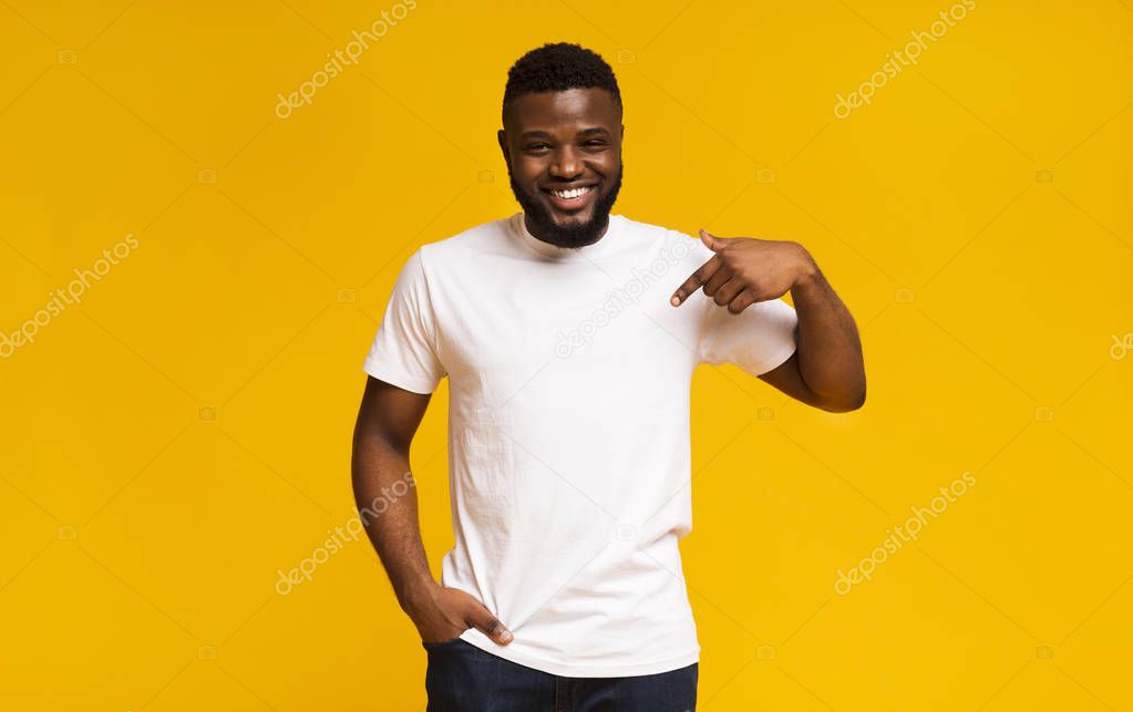 Look at my new t-shirt. Young black man pointing at blank space of his clothes