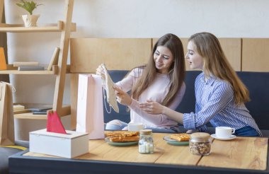 Genç çekici kadın arkadaşı yeni çanta gösteren