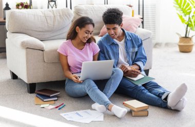 Genç Afrikalı öğrenciler evde birlikte dizüstü bilgisayar üzerinde çalışıyor