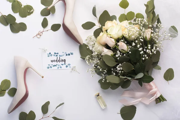 Posa piatta di bouquet da sposa e scarpe con tacco alto su bianco — Foto Stock