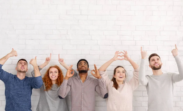 Jóvenes amigos mostrando varios gestos sobre la pared blanca — Foto de Stock