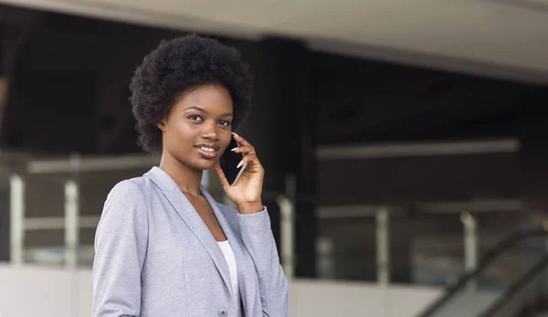 Mujer africana joven hablando por teléfono en frente del centro de negocios — Foto de Stock
