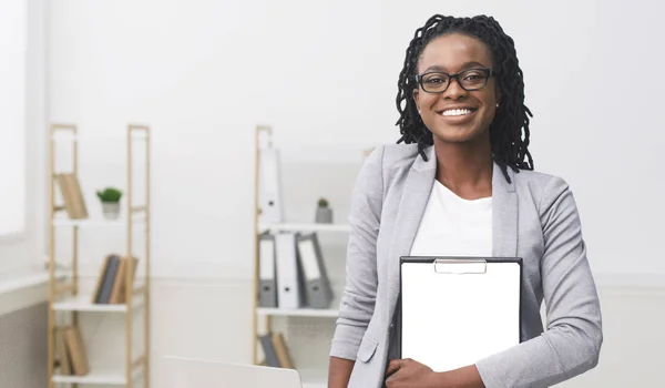 Afro-americano empresária segurando pasta sorrindo para câmera no escritório — Fotografia de Stock