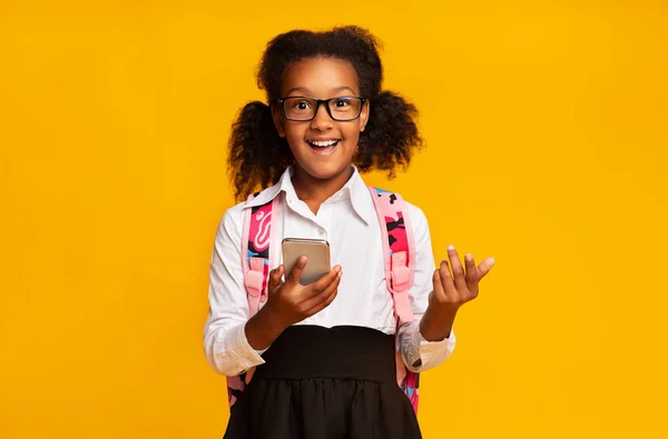 Šťastná africká americká školka při procházení mobilu, žluté pozadí — Stock fotografie