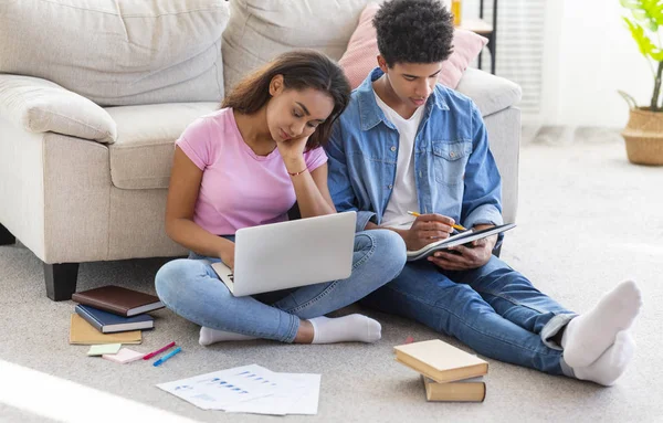 Evde sınavlara hazırlanan yorgun öğrenciler, yerde oturuyor