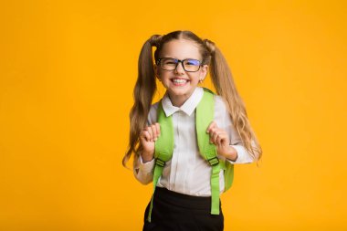 Mutlu Schoolgirl Kamera, Sarı Arka Plan, Studio Shot At Poz Gülümseyen