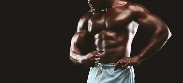 Preto atleta masculino demonstrando seus músculos abdominais — Fotografia de Stock