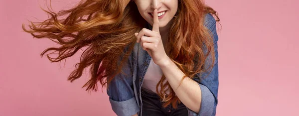 Oigenkännlig rödhårig flicka som visar tystnad skylt håller pekfingret på läpparna — Stockfoto