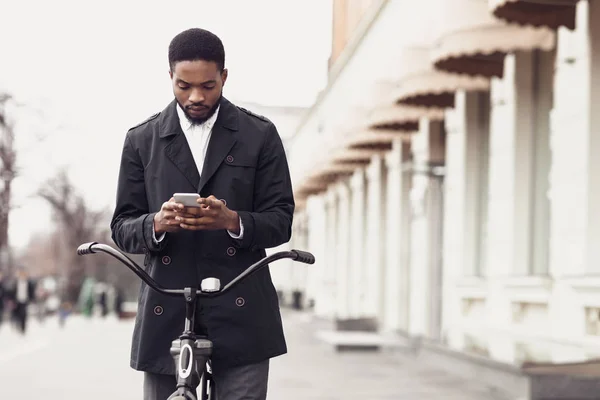 Homem de terno mensagens no telefone, de pé com bicicleta na rua — Fotografia de Stock