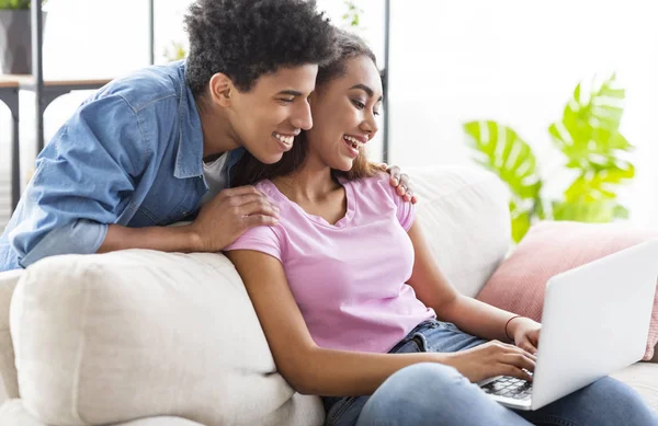 Mutlu genç çift evde dizüstü bilgisayarda internet tarama