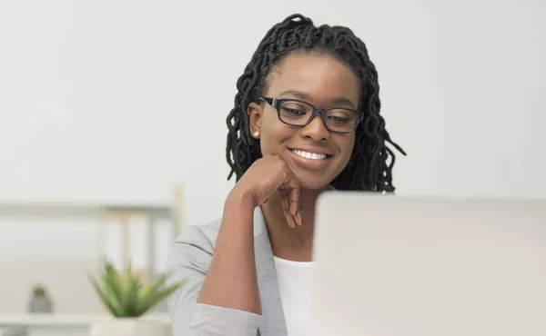 Allegro afro ufficio signora lavoro su computer portatile in ufficio moderno — Foto Stock