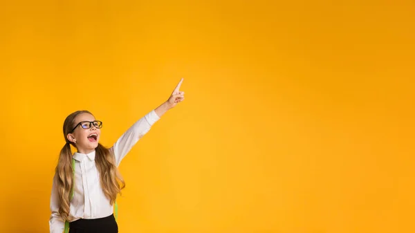 Ragazza studentessa elementare che indica dito in su, Studio girato, Panorama — Foto Stock