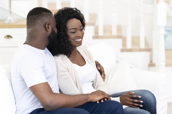 Romantic couple sitting on couch, embracing each other — Stock Photo, Image