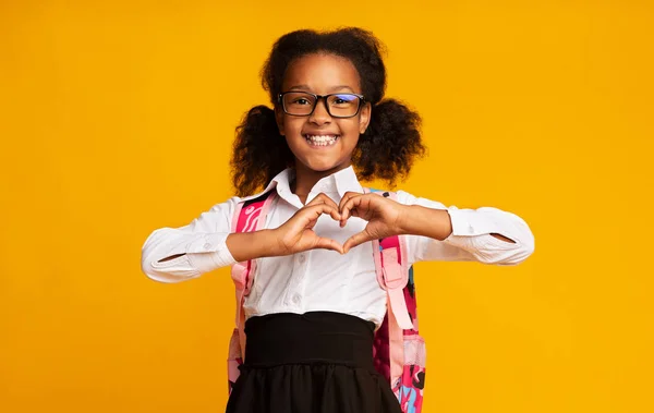 African American schoolmeisje toont hart gebaar met handen in de Studio — Stockfoto